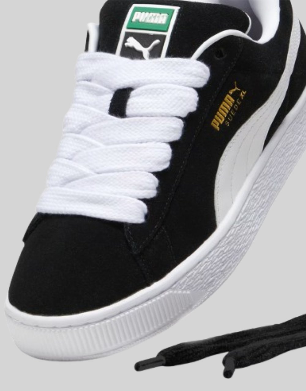 Three-quarter view of Puma Suede XL pair in black suede with white Formstrip and oversized white laces