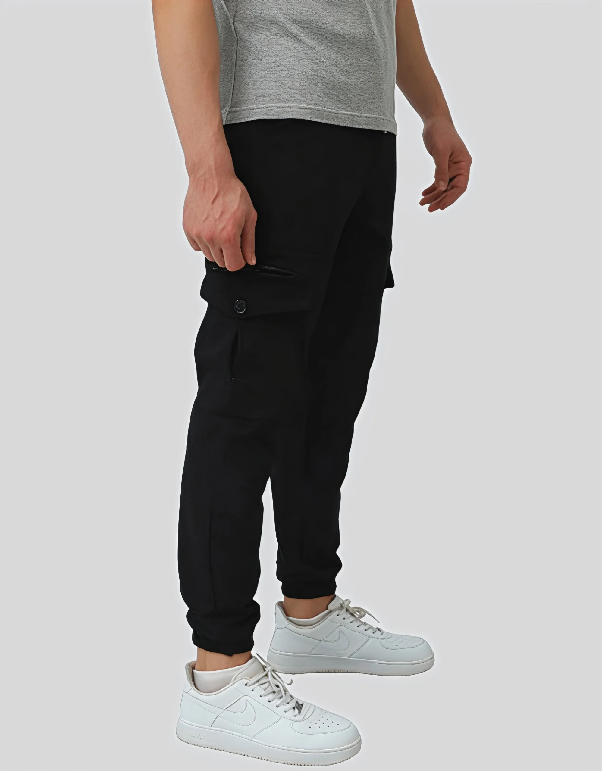 Men's black cargo jogger pants worn on model right side view showing button-closure cargo pocket and slim tapered fit