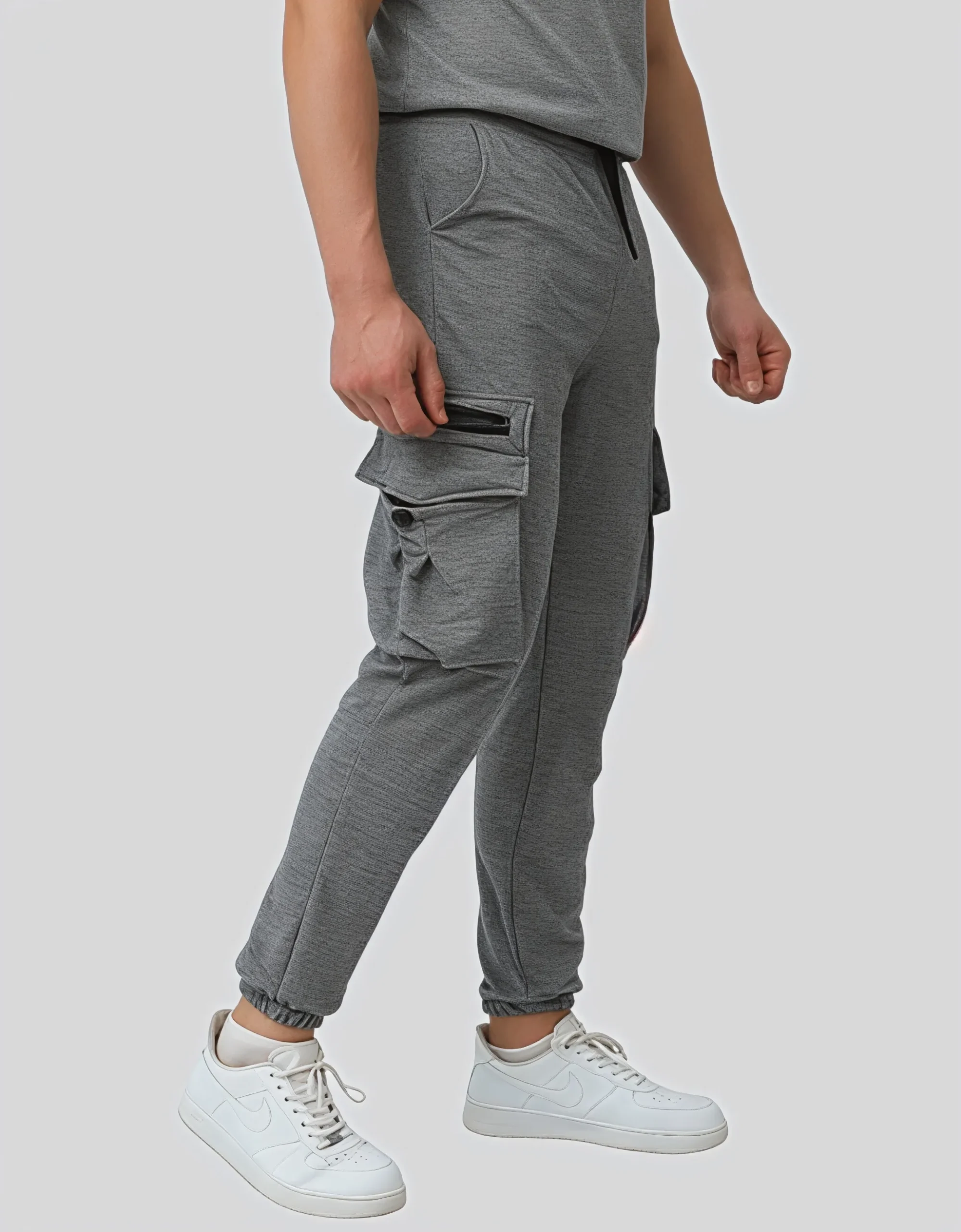 Men's gray cargo jogger pants worn on model right side view showing zippered cargo pocket detail and slim tapered fit
