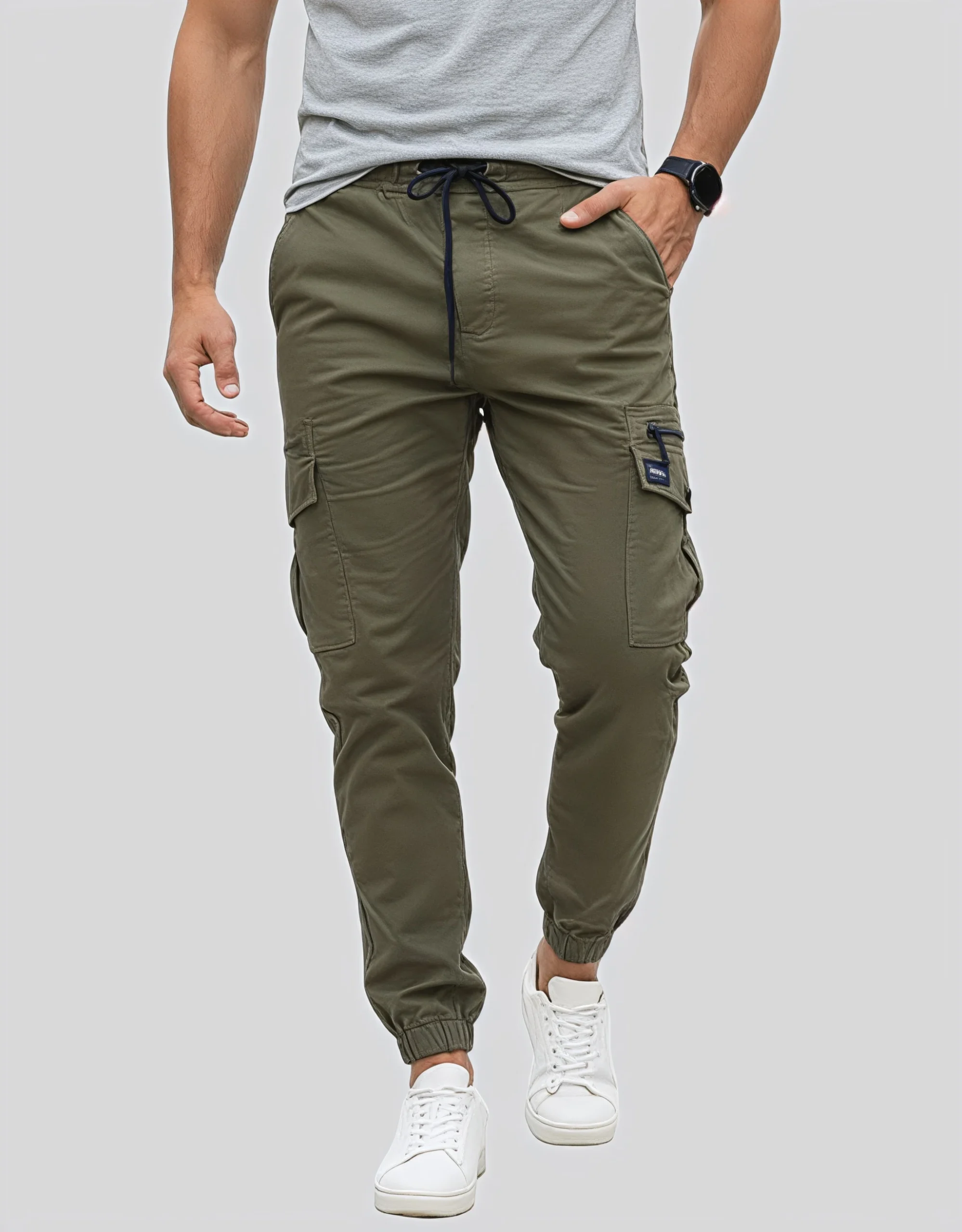 Men's military green cargo jogger pants worn on model front view showing dual cargo pockets navy blue drawstring waistband and slim tapered silhouette