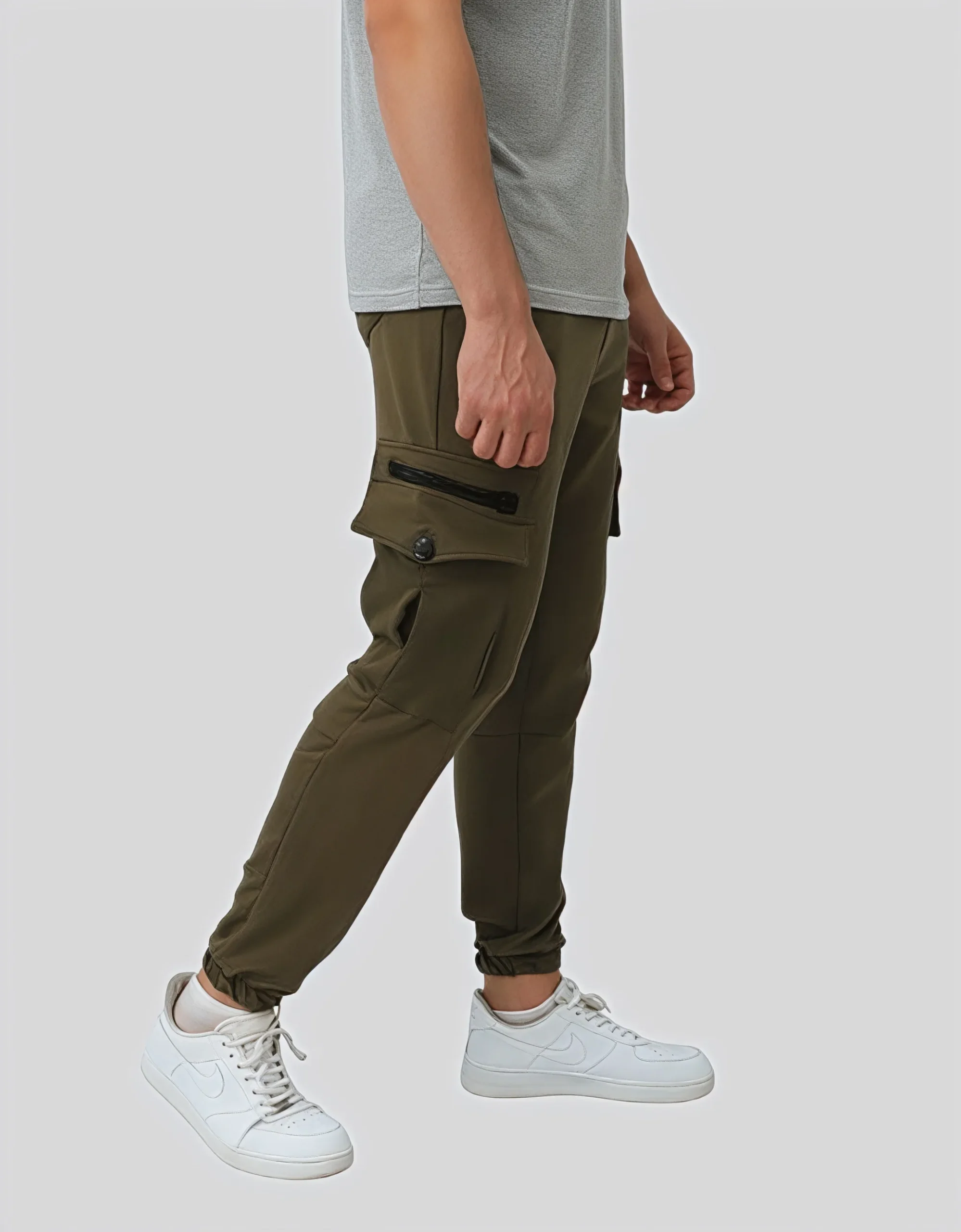 Men's military green cargo jogger pants worn on model right side view showing zippered cargo pocket detail and slim tapered fit