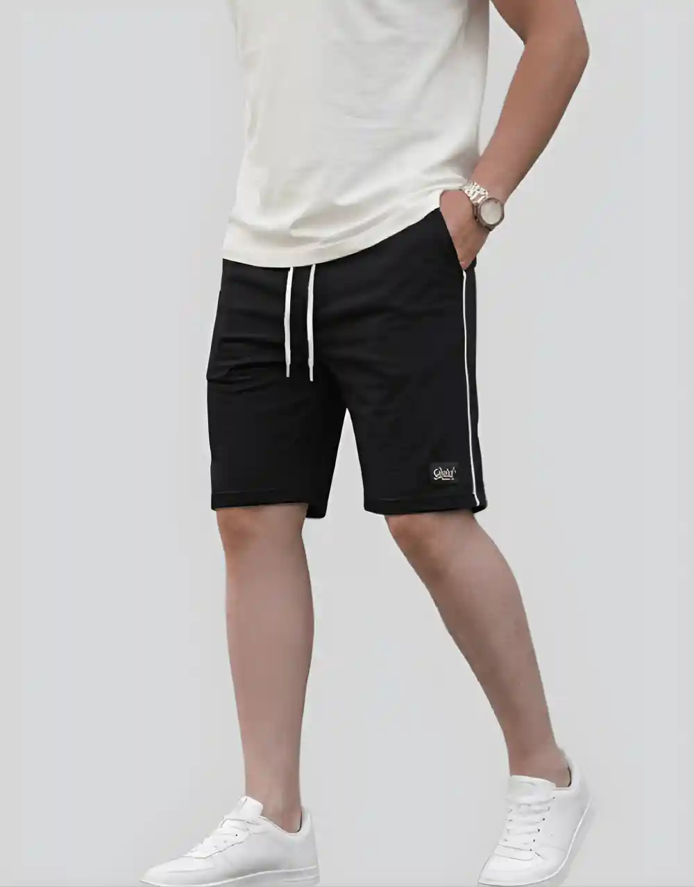Men's black cotton shorts with white side piping worn on model side view with white sneakers