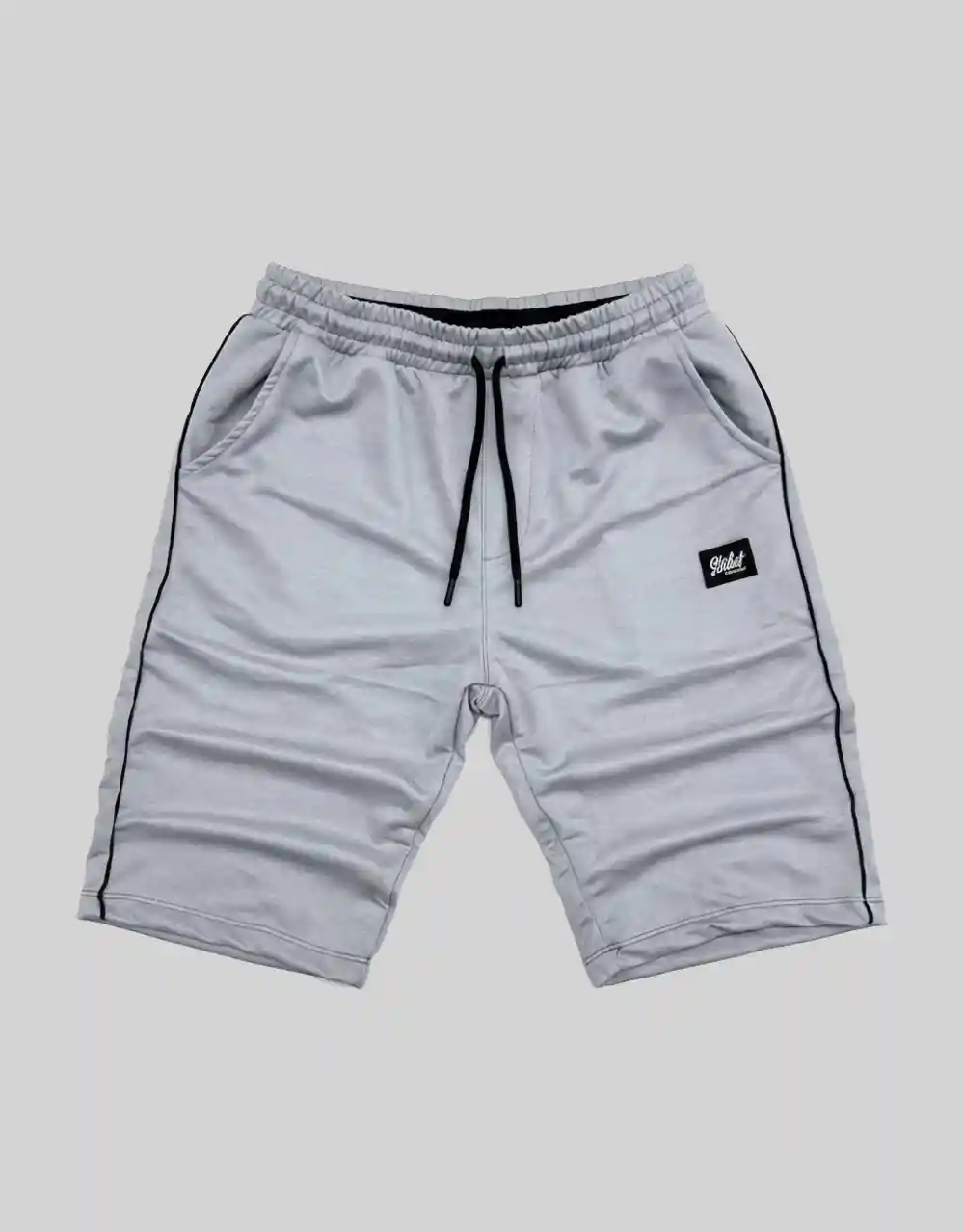 Flat lay of men's light grey cotton shorts with black contrast side piping and branded patch