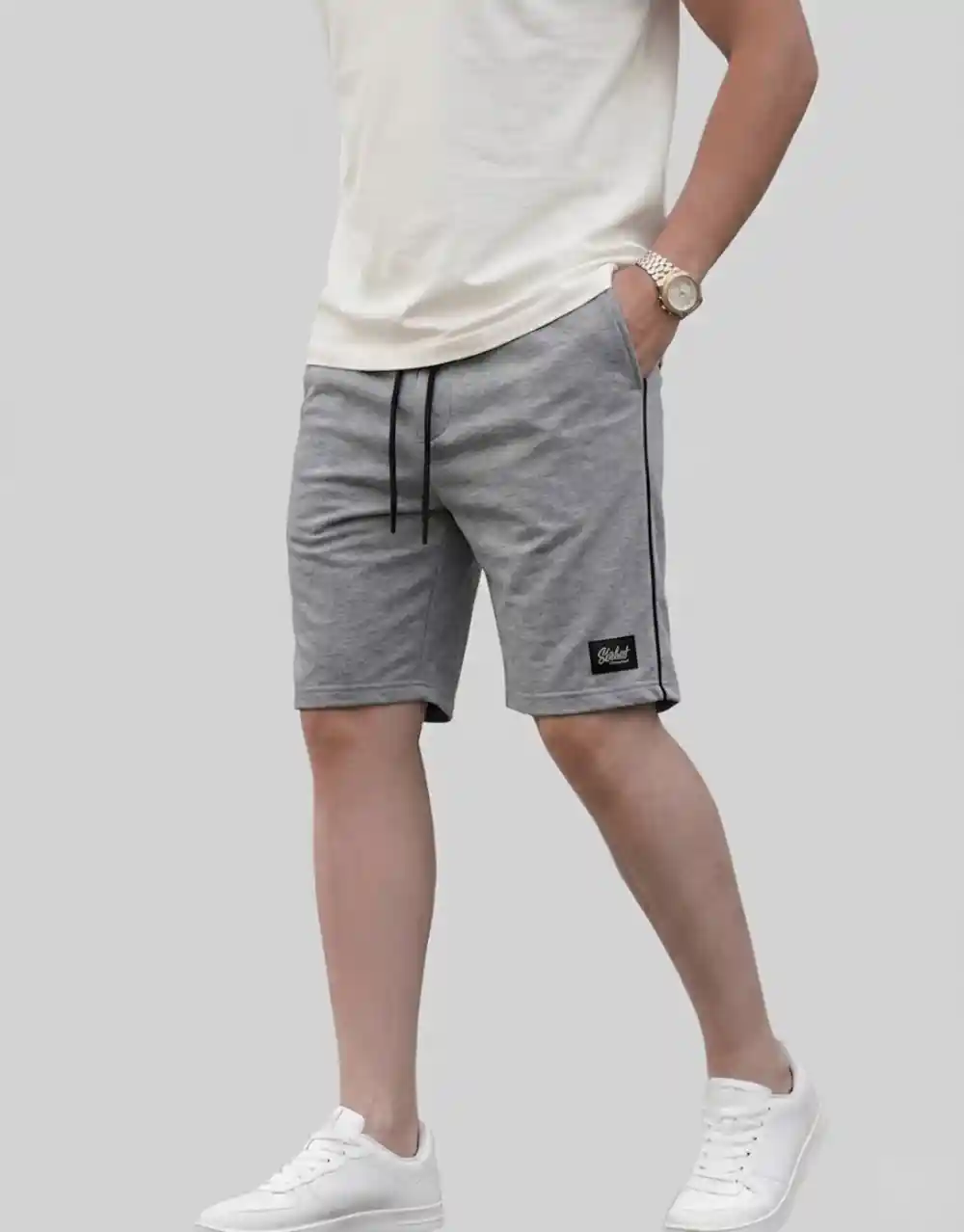 Men's light grey cotton shorts with black side piping worn on model side view